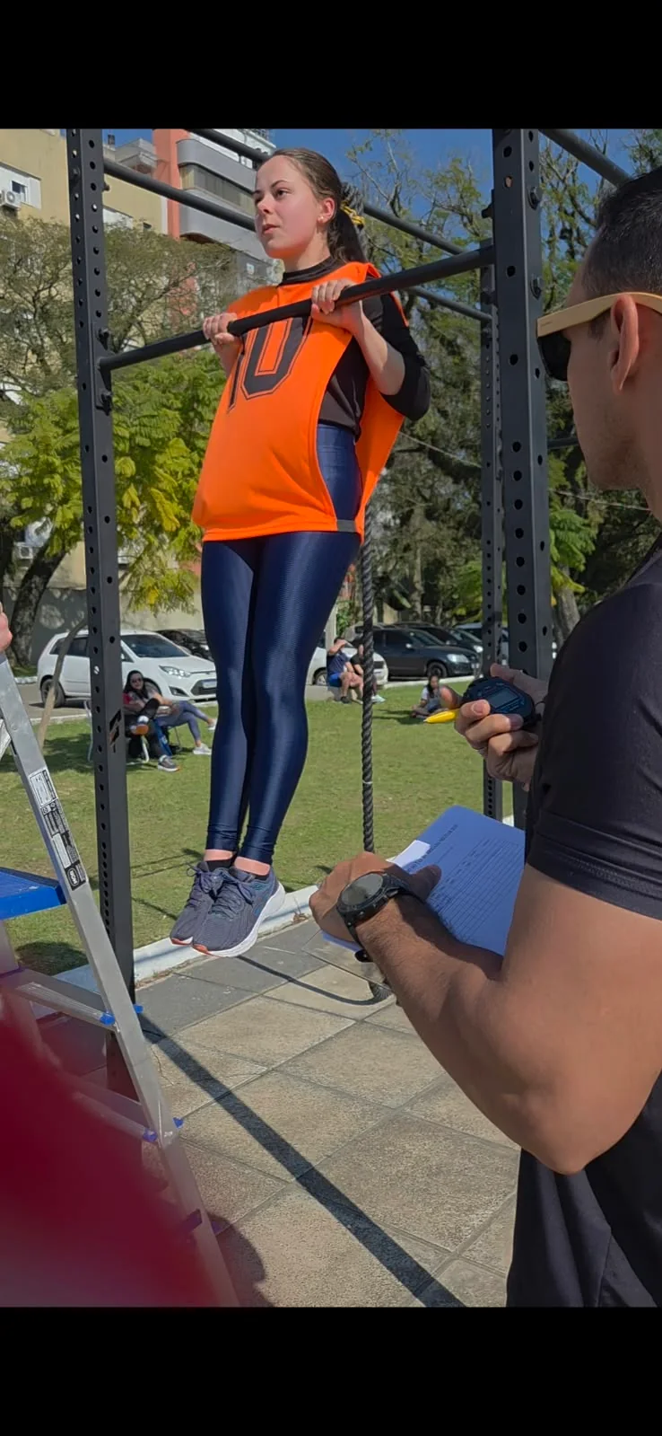 Maicon acompanhando uma participante durante exercício de barra no evento.