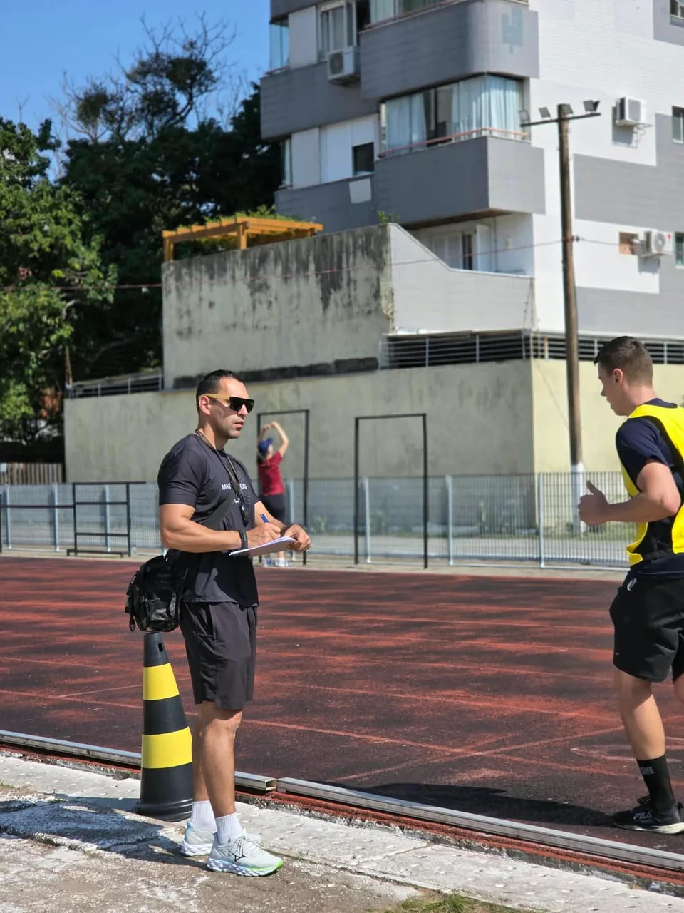 Maicon com uma prancheta acompanhando um participante na pista.